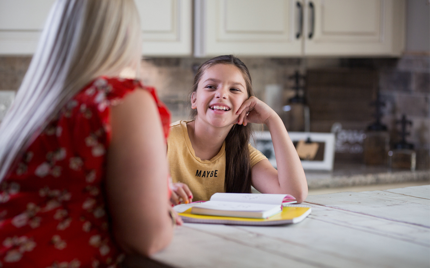 Cochlear recipient Holly doing homework at the kitchen with her mother