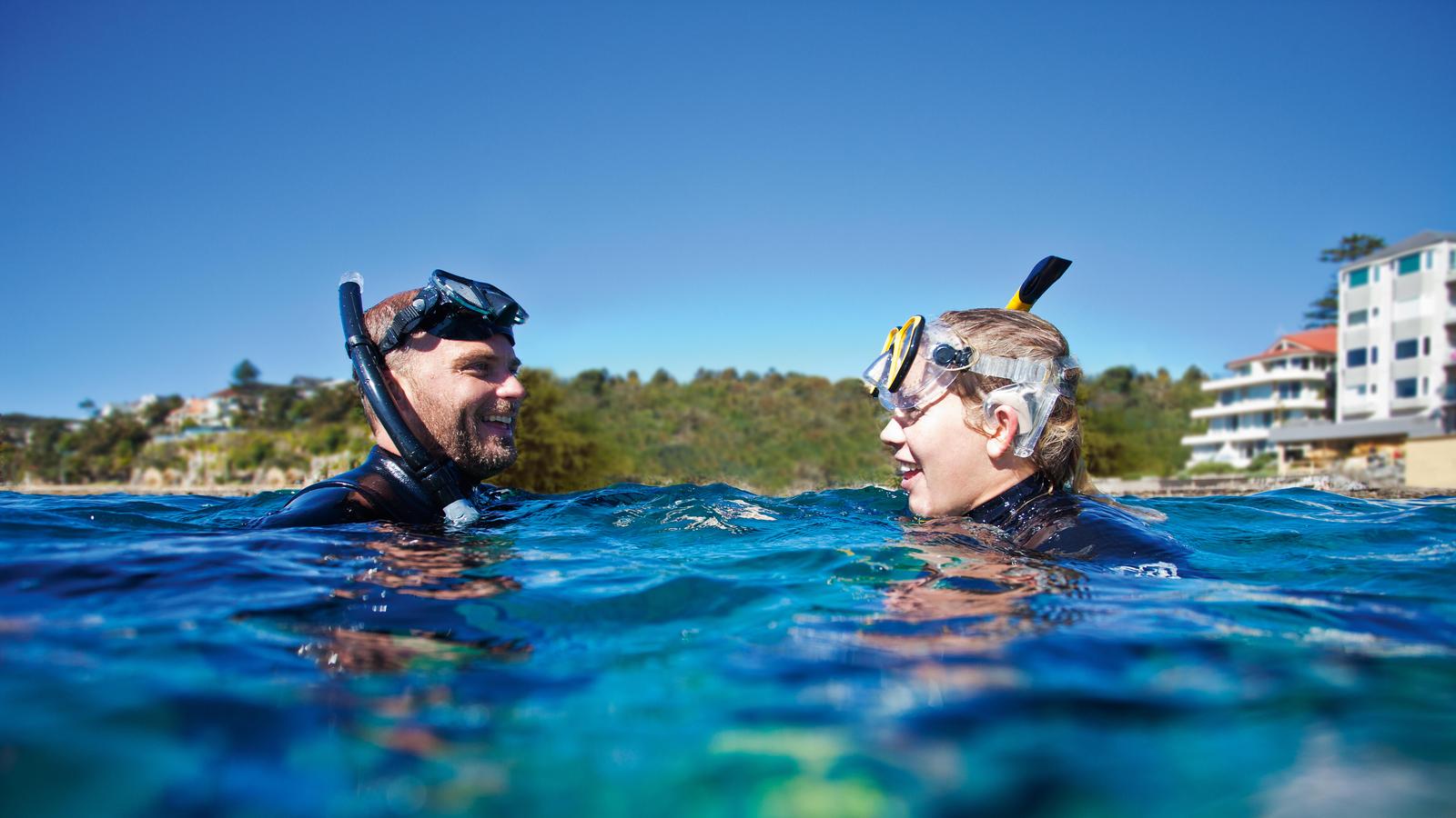 Een man draagt een Nucleus waterbestendig accessoire terwijl hij met een vriend gaat snorkelen 