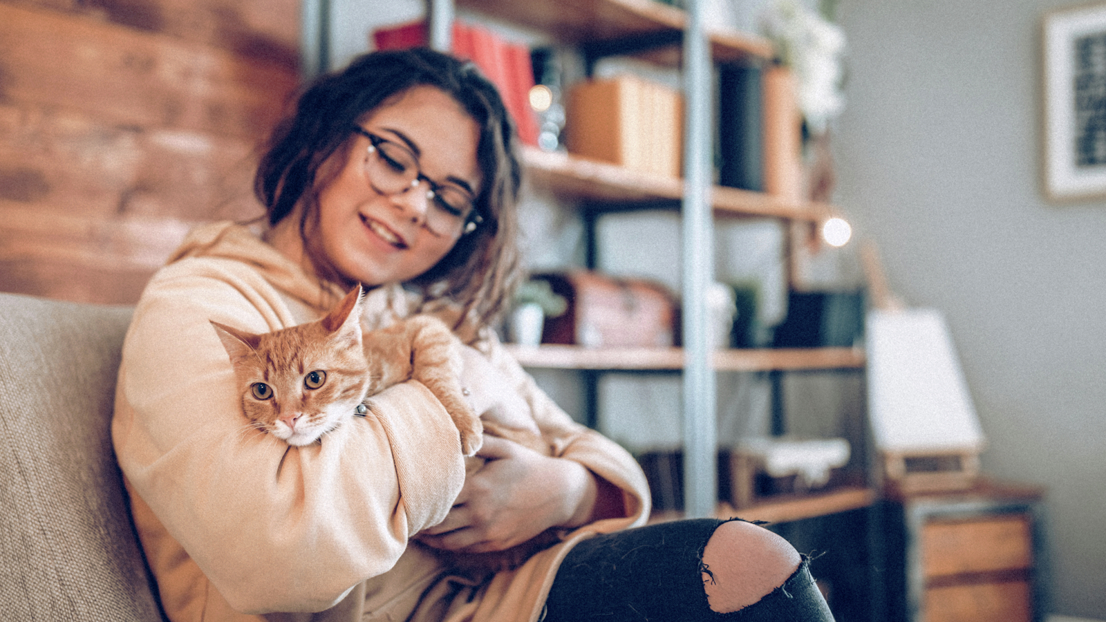 Una niña con un gato sentada en un sofá